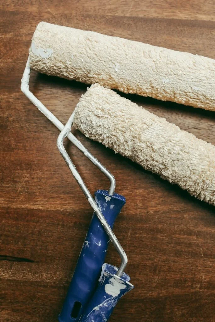 close up photo of paint rollers on wooden surface